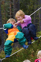 Children in a Norwegian naturbarnehage (nature nursery) rope walking, Trondheim, Norway, 2006