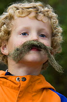 Boy in a Norwegian naturbarnehagen (nature nursery) with a lichen moustache, Trondheim, Norway 2006