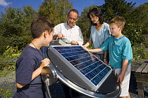 Family with with solar panel display at the Centre for Alternative Technology, Machynlleth, Wales