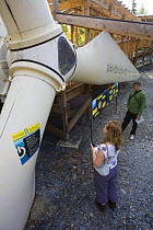 Visitors looking at wind turbine installation at the Centre for Alternative Technology, Machynlleth, Wales