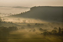 Cam Long Down shrouded in mist from Coaley Peak on the Cotswold Way, Gloucestershire, England