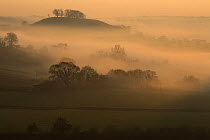 Downham Hill shrouded in mist from Coaley Peak on the Cotswold Way, Gloucestershire, England