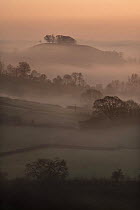 Downham Hill shrouded in mist from Coaley Peak on the Cotswold Way, Gloucestershire, England