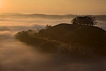 Downham hill in mist at sunset from Uley Bury, Gloucestershire, England