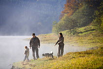 Family walking alongside Talybont reservoir in the Autumn, Brecon Beacons National Park, Powys, Wales