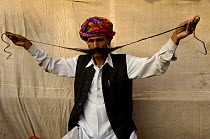Rajasthani man showing off his long moustache. Pushkar camel and livestock fair, Pushkar, Rajasthan, India, October 2006