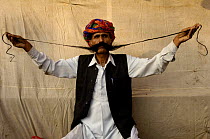 Rajasthani man showing off his long moustache. Pushkar camel and livestock fair, Pushkar, Rajasthan, India, October 2006