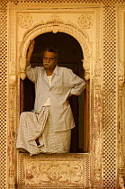 Rajasthani man standing in the doorway of a sandstone Haveli (merchants house), Bikaner, Rajasthan, India 2006