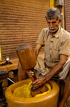 Rajasthani man mixing ingredients for Indian sweets. Jaisalmer, Rajasthan, India