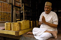 Tobacco and snuff seller in bazaar of Jodhpur, sitting in half lotus position Rajasthan, India 2006