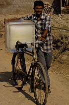 Ice block being delivered by bicycle near the city of Bhavnagar in Gujarat, India 2006