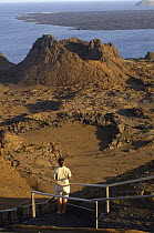 Tourist looking at a landscape of lava and ash, Bartolome Island, Galapagos