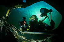 Diving photographer photographing underwater wreck