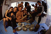 Divers with porcelain recovered from WWII shipwreck, Borneo
