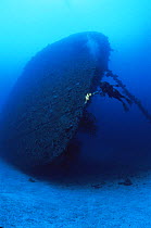 Diver with torch exploring shipwreck of the WWII 'Nippo Maru', Truk / Chuuk Lagoon, Chuuk islands, Pacific ocean