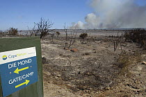 Sign next to charred landscape after controlled burning, DeHoop NR, Western Cape, South Africa
