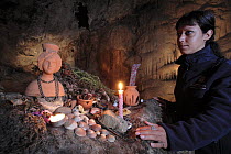 Woman at shrine inside Cuieram cave, Ibiza, Balearic Islands, Spain