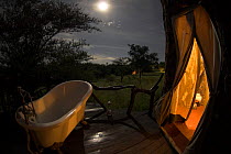 Balcony bath tub by moonlight outside safari tent. Mbalageti Tented Camp, Serengeti National Park, Tanzania.