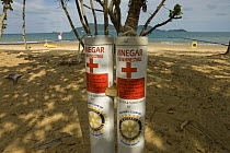 Tubes containing vinegar to treat Box Jellyfish sting, with stinger-resistant enclosure in background, Queensland, Australia  2006