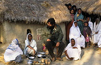 Presenter Valmik Thapar with widows of men attacked by man-eating tiger, Sunderbans, Bengal, India. On location for BBC NHU 'Land of the Tiger - Sacred Waters', December 1996