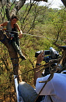 John Waters filming Presenter Charlotte Uhlenbroek on a zip wire. On location in Madagascar, filming for BBC television series 'Cousins', 1999