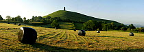 Glastonbury Tor at dawn with bagged hay bales in foreground, Somerset, UK. Digital Composite