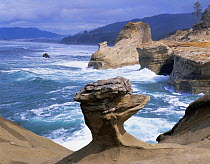 Sea surf against sandstone cliffs and rock formationa on the shore at Cape Kiwanda State Park, Oregon, USA