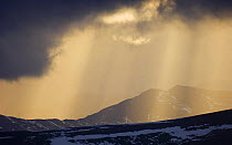 Sun shining though clouds, Grampian mountains, February, Glenshee, Scotland, UK