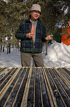 Geologist studying and explaining mineral cores, Northwest Territories, Canada March 2007