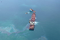 Aerial view of the shipwrecked 'Napoli' with tugs and oil visible on water's surface, near Sidmouth and Branscombe, Devon, UK, 2007
