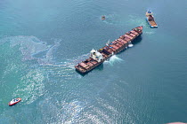 Aerial view of the shipwrecked 'Napoli' with tugs and oil spill visible on water's surface, near Sidmouth and Branscombe, Devon, UK, 2007