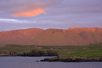 Isle of Rum at sunset as seen from Isle of Canna. Inner Hebrides, Scotland. June.