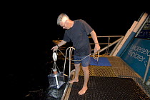 Dr Billy Sinclair deploying his light trap to attract plankton aboard a research vessel (researchers from Central Queensland University, Rockhampton). Queensland, Australia