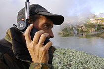 Photographer Igor Shpilenok reporting by satellite phone on events after major landslide in Valley of the Geysers, Kamchatka, Russia, June 3, 2007.