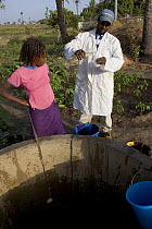 Scientist testing water purity at well, Bakau rice fields, Gambia (Reconstruction) 2007
