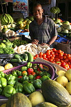 Young AFrican man working in fruit and vegetable market stall, Bakau market, Gambia, 2007