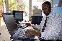Gambian man working on computer, 2007.