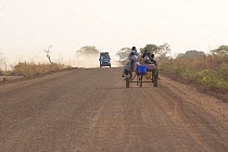 Donkey cart and truck travelling on dust road, near Farafenni, Gambia, 2007