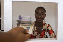 Woman bank clerk in foreign exchange office, Senegambia, Gambia, 2007