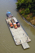 Trucks coming from either Coca or Lago Agrio cross the Napo river by barge before travelling on to various oil company instalations in the Yasuni National Park, Amazonia, Ecuador