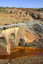 Bridge over the Riotinto river, mineral rich soil mined for iron which seeps into and discolours the river water, Huelva, Spain
