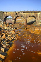 Bridge over the Riotinto river, mineral rich soil mined for iron which seeps into and discolours the river water, Huelva, Spain