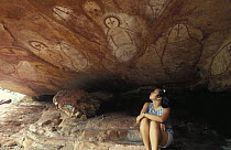 Tourist viewing the ancient aboriginal Wandjina rock art  in cave, Bigge Island, Western Australia