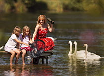 Family - woman and two girls - playing with net at a lake in Northamptonshire, England. July 2007