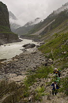 People trekking along river in Yarlung gorge, Tibet, May 07. 'Wild China' series