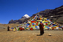 Tibetan Monk and prayer flags, with Mount Kailash in the background, Tibet