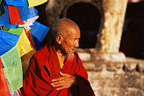 Pilgrim / Monk and prayer flags at Jokhang Temple, Lhasa, Tibet   2007