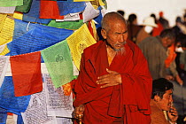 Pilgrim / Monk and prayer flags at Joklang Temple, Lhasa, Tibet 2007