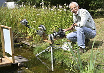 Photographer Kim Taylor setting up a fully automated system to photograph a dragonfly patrolling over a pond. Surrey, UK