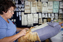 Woman working with lace bobbins in her workshop, Galicia, Spain